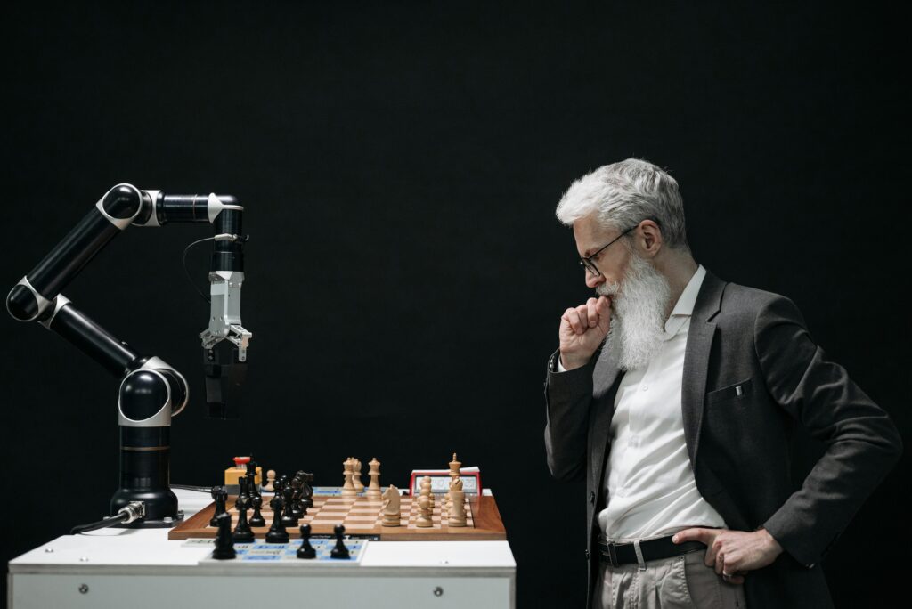 Man playing chess with AI robotic arm