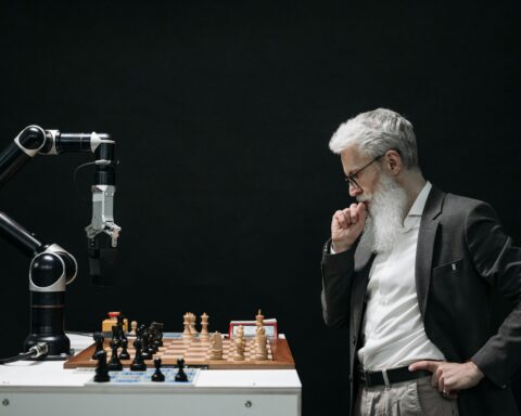 Man playing chess with AI robotic arm